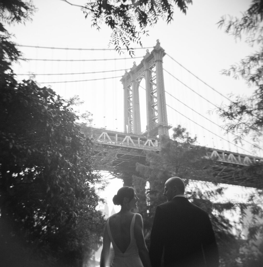 bride and groom in front of brooklyn bridge