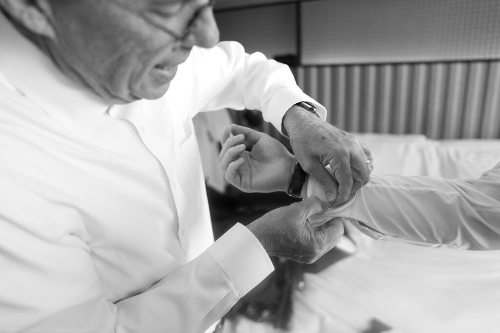father of bride helping groom with button at Celestine Wedding