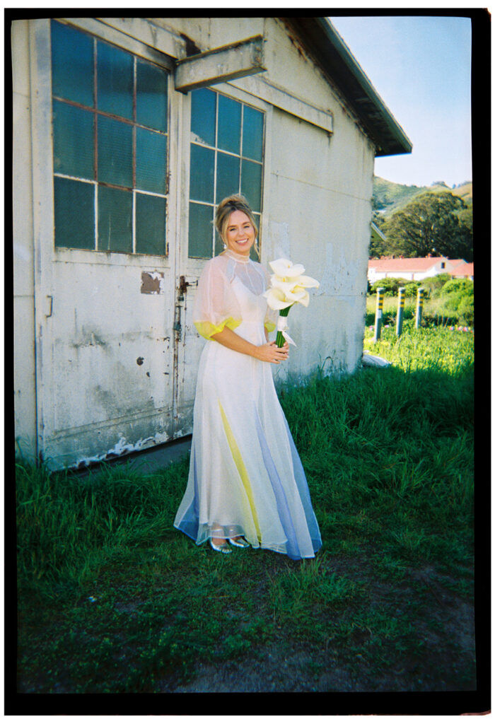 bride holding flowers in front of boat house at san francisco wedding at travis marina