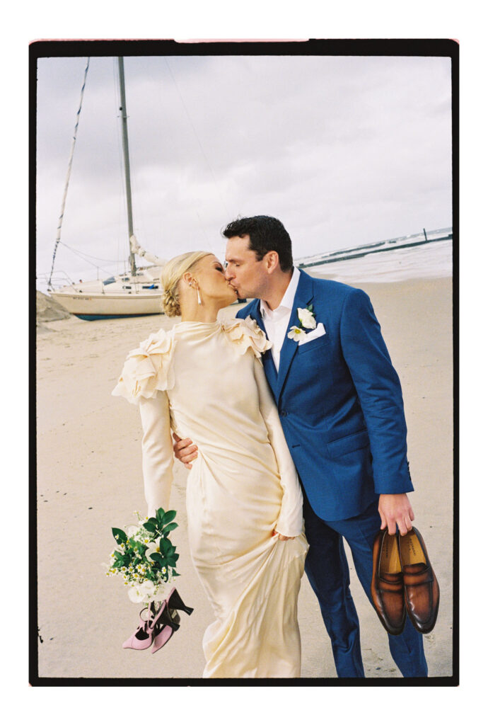 Couple walking on the beach near shipwreck during Jersey Shore wedding