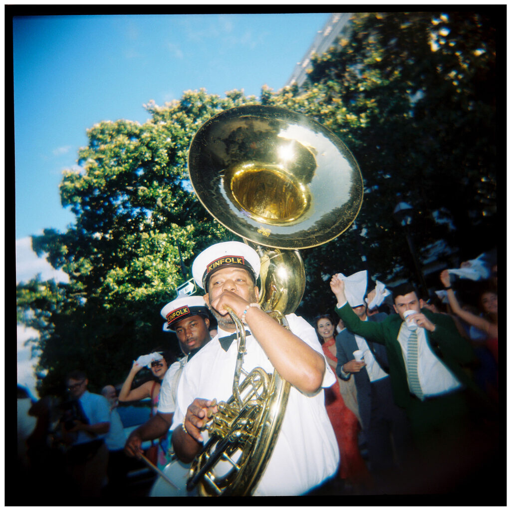 Marching band walking with wedding party around the block at brennan's wedding in new orleans