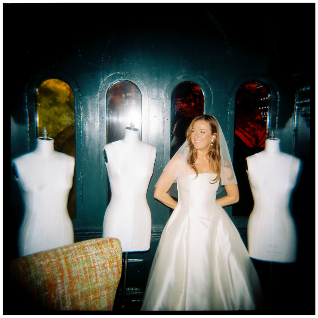 bride getting ready and standing in front of maniquins, taken at hotel st vincent before ceremony at st mary's new orleans church