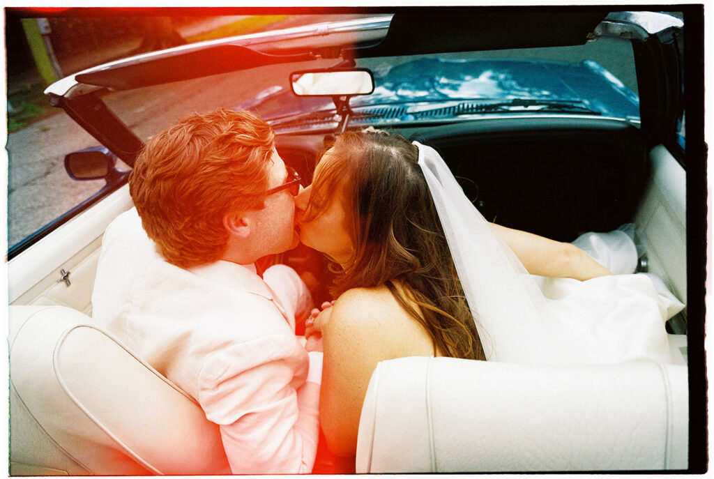 new orleans wedding pictures with bride and groom kissing after send off in a vintage car
